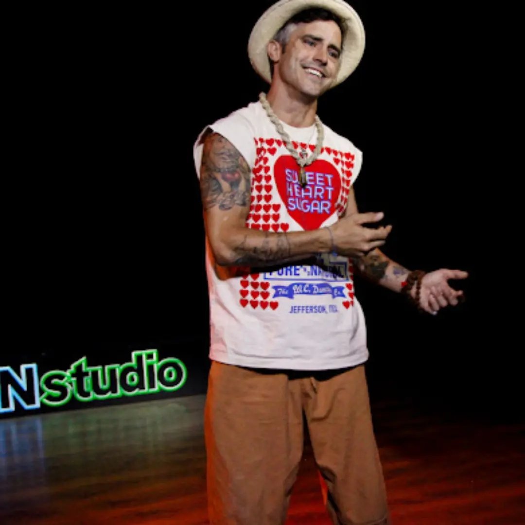 Cam "the" Poet mid-performance on stage in a straw hat